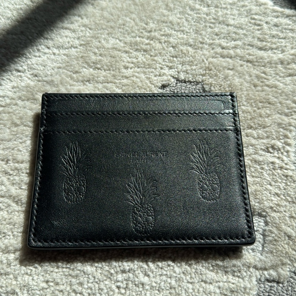 SAINT LAURENT
Pineapple Embossed Card Holder in Black, Skulls and pineapple.